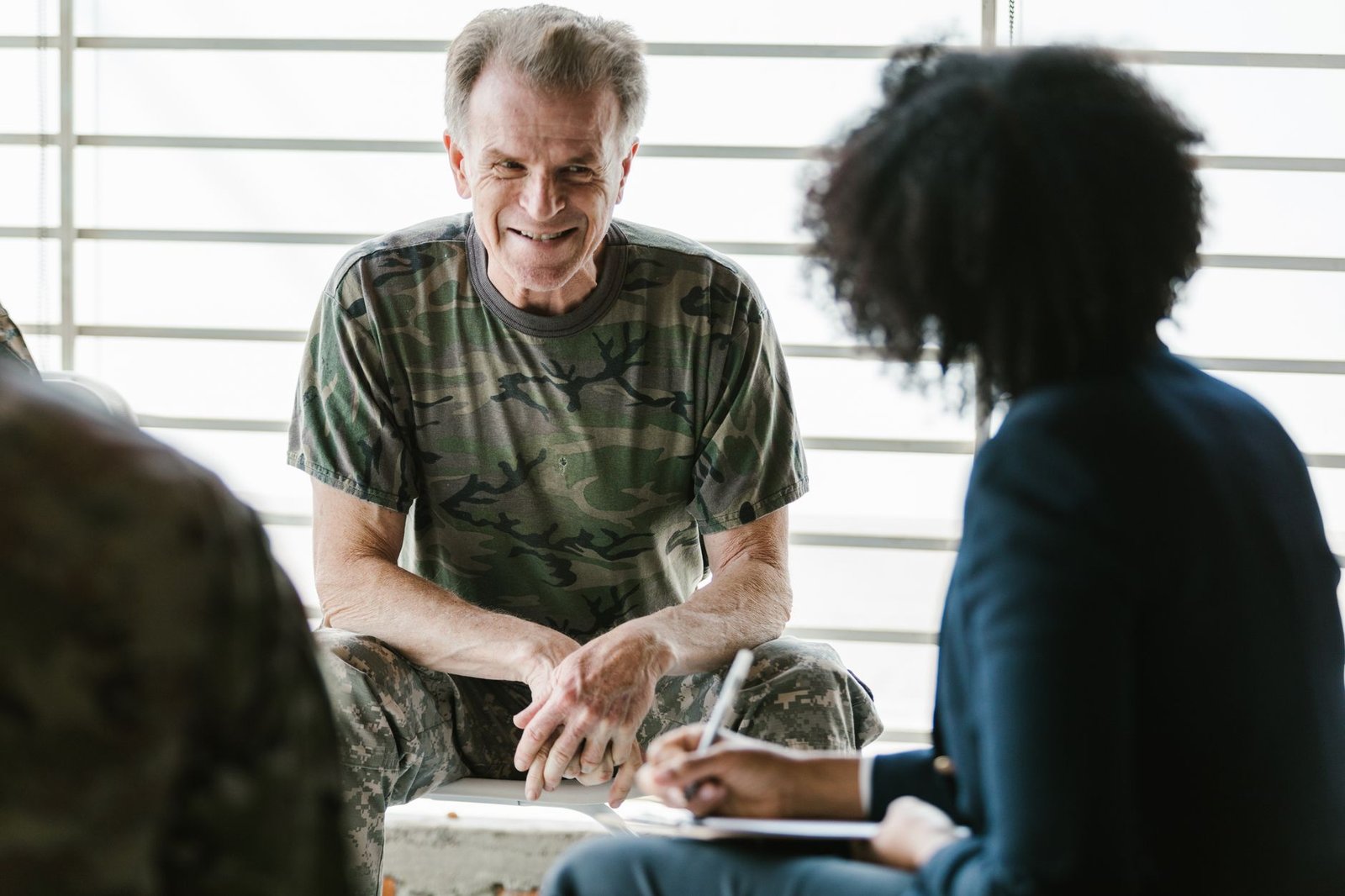 Retired military firefighter discussing asbestos exposure benefits with a counselor