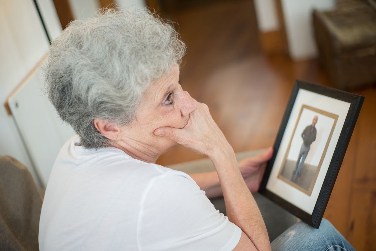 Surviving spouse at home with a framed service photo, weighing remarriage and VA benefits